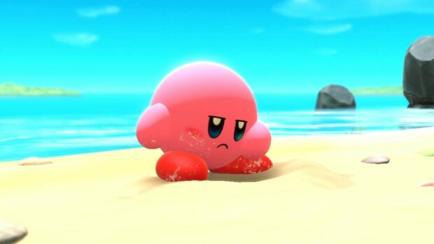 Kirby and the Forgotten Land character sitting on the sandy beach with a calm sea background