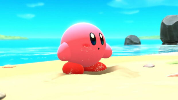 Kirby And The Forgotten Land character standing on sandy beach near the ocean scene