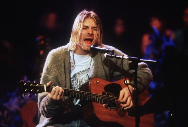 Kurt Cobain performing passionately with guitar on stage