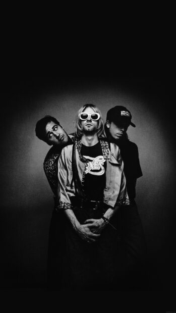 Kurt Cobain with bandmates posing in black and white photo with Kurt Cobain in signature sunglasses