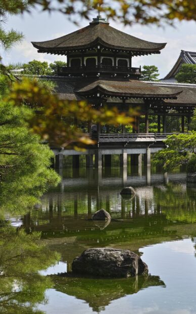 Traditional Kyoto architecture reflected in a peaceful garden pond surrounded by lush greenery