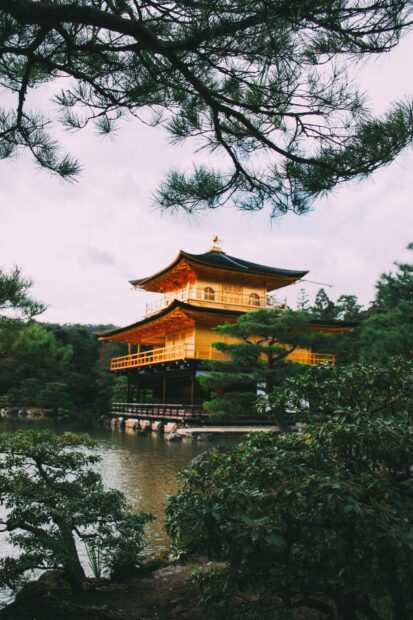 Traditional Kyoto architecture surrounded by lush greenery and water in HD quality