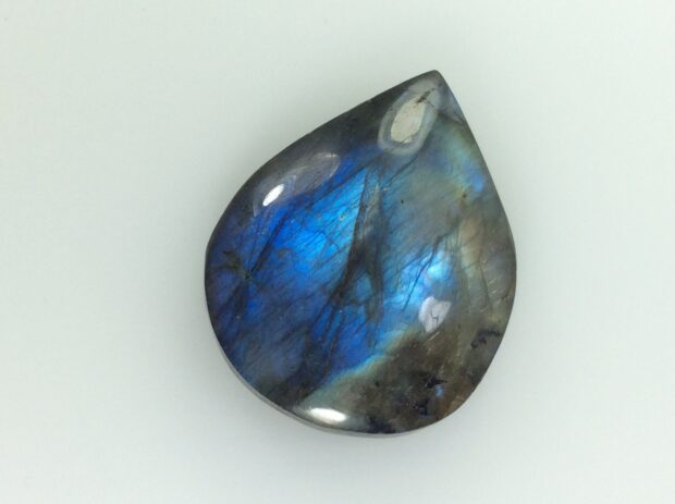 A polished labradorite stone showing vibrant blue and gray colors with natural patterns