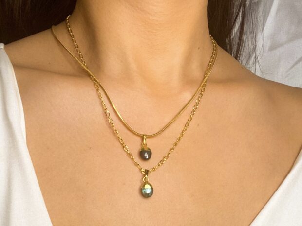 Close up of labradorite pendant necklaces on a woman’s neck