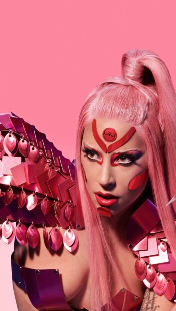 Lady Gaga with pink hair and artistic red face paint in a futuristic outfit