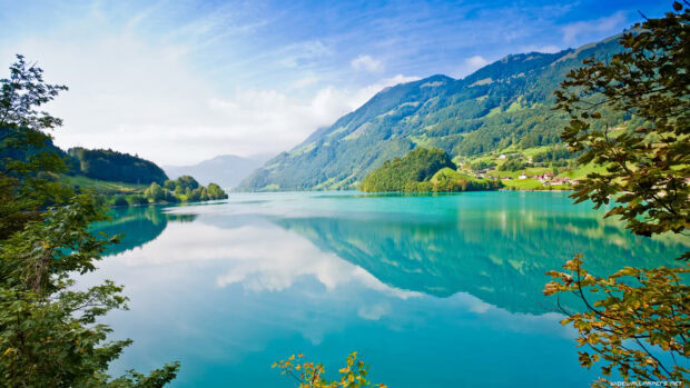 A serene lagoon surrounded by lush green hills under a clear blue sky