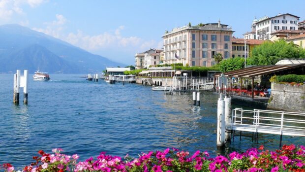 Beautiful Lake Como scenery with colorful flowers and boats on the water