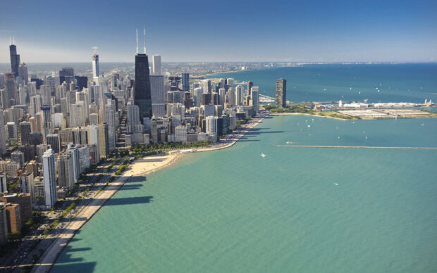 Aerial view of Lake Michigan with cityscape along the shoreline and numerous buildings in the background
