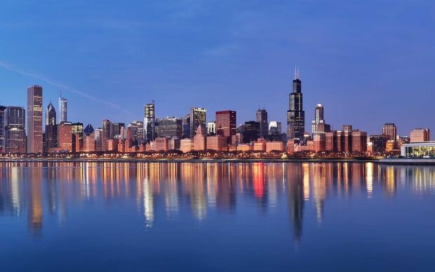 Evening city skyline over lake Michigan with clear sky and building reflections