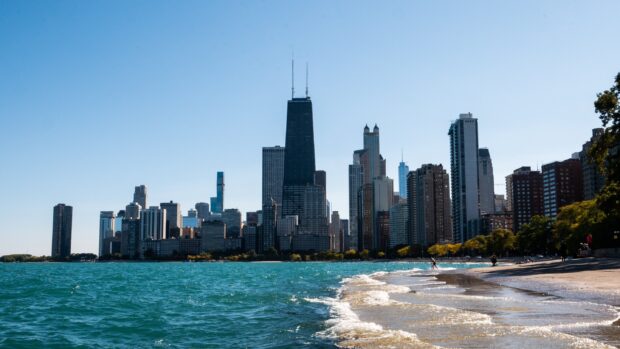 The Chicago city skyline along Lake Michigan with clear blue skies and calm waters