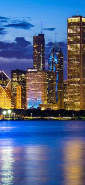 Evening city skyline with lake michigan reflecting city lights and tall buildings