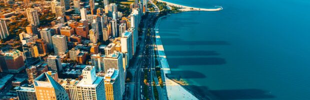 Aerial view of Lake Michigan shoreline with city buildings and roads in vibrant sunlight