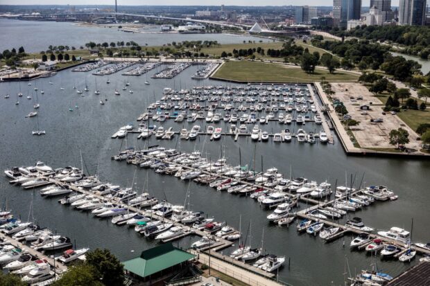 Aerial view of Lake Michigan marina with numerous boats docked and city skyline in the background