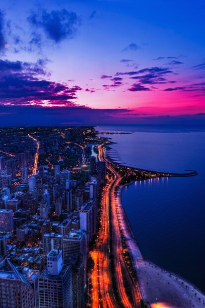 Stunning aerial view of Lake Michigan at sunset with city lights along the shore