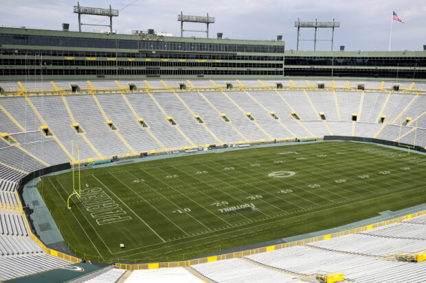 A wide view of Lambeau Field stadium showcasing the empty seats and football field on a clear day
