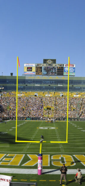 Lambeau Field stadium with football players and crowd on a sunny day