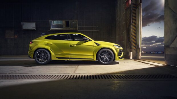 Lime green Lamborghini Urus SUV parked inside a dark garage with open door and evening sky visible outside