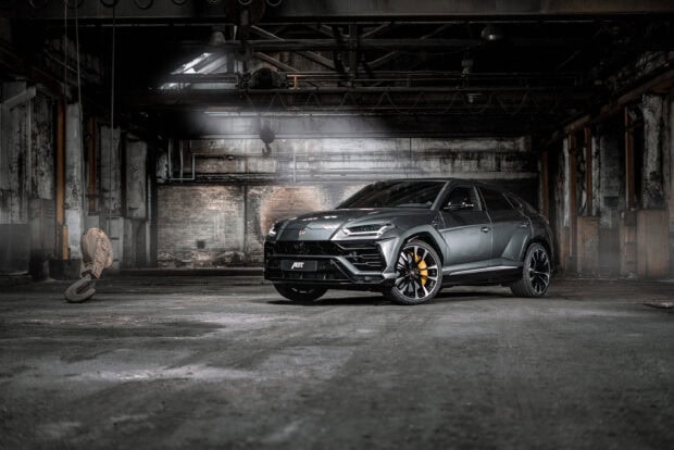 A Lamborghini Urus parked inside an industrial warehouse with rustic walls and concrete floor