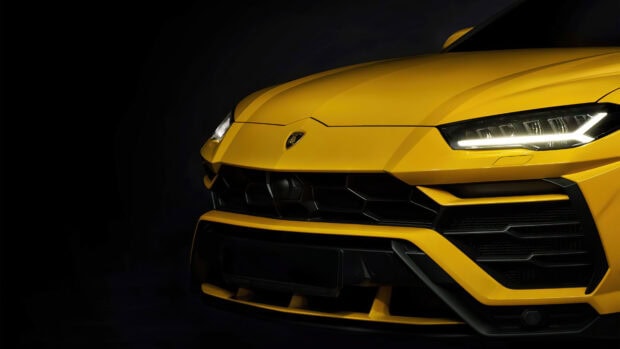 Yellow Lamborghini Urus front view showcasing sharp headlights and aggressive grille design