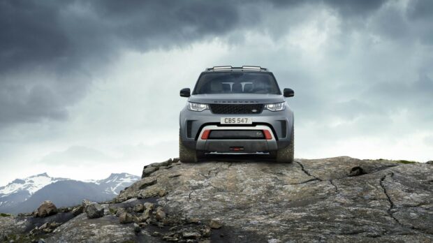 Land Rover Discovery vehicle on rocky terrain with mountainous landscape in background