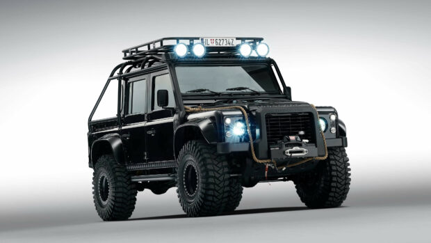 Black Land Rover with rugged tires and roof lights displayed in high resolution