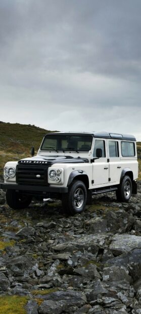 White Land Rover off road vehicle standing on rocky terrain under cloudy sky