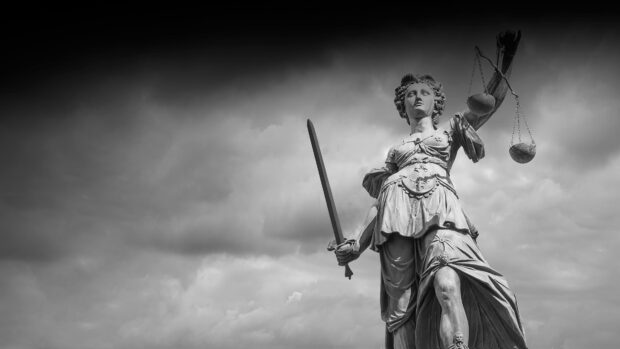 Statue of justice holding sword and scales representing lawyer ethics and law