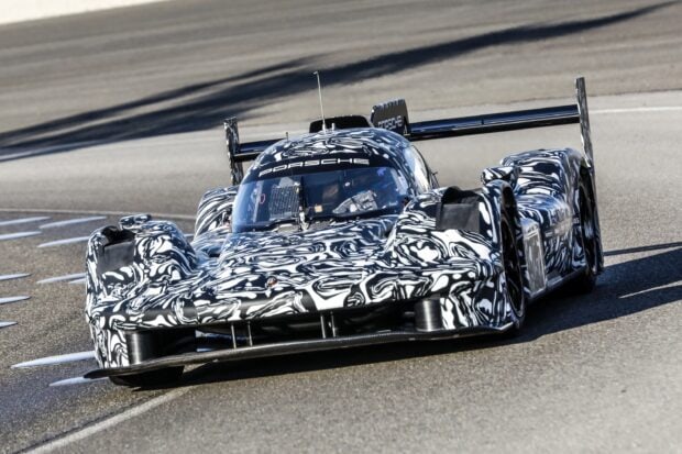 Porsche racing car testing at Le Mans track with camouflage design