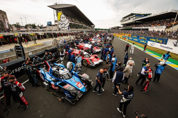 Race cars and teams preparing on pit lane at Le Mans circuit before the race starts
