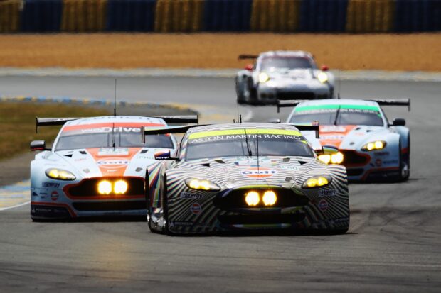 Aston Martin racing cars at Le Mans track during a high speed race