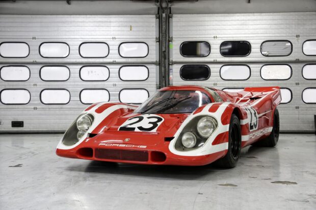 Classic Porsche race car with number 23 at Le Mans in a garage setting