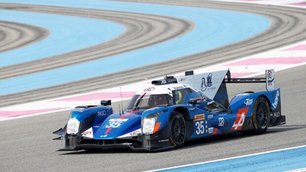 Blue race car number 35 speeding on Le Mans track with racing stripes and sponsor logos