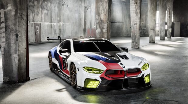 BMW M Motorsport racing car in Le Mans design parked in industrial garage with concrete pillars