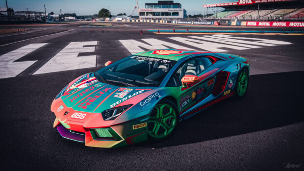A colorful racing car with sponsor decals at Le Mans racing circuit
