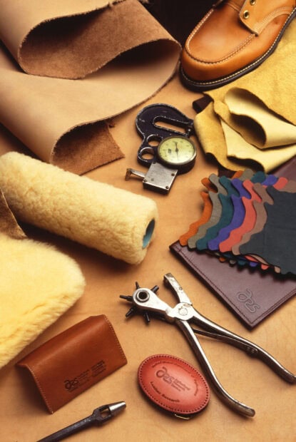 Various leather materials and tools used for leather crafting including swatches and measuring devices