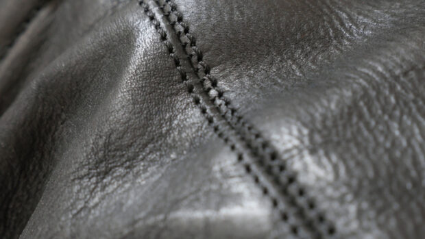 Close up of leather texture with detailed stitches and natural grain pattern