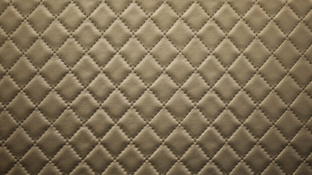 Close up of quilted leather texture with detailed stitching pattern
