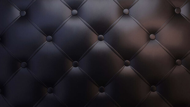 Dark leather surface with button tufted pattern and smooth texture
