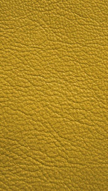 Close up of textured yellow leather surface with natural grain pattern