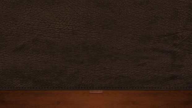 Dark leather texture with detailed natural grain pattern on a wooden surface