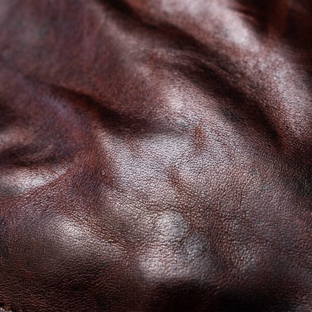 Smooth textured leather surface with natural wrinkles and rich brown color