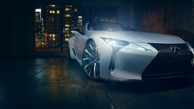 White Lexus car with shining headlights parked inside a garage at night