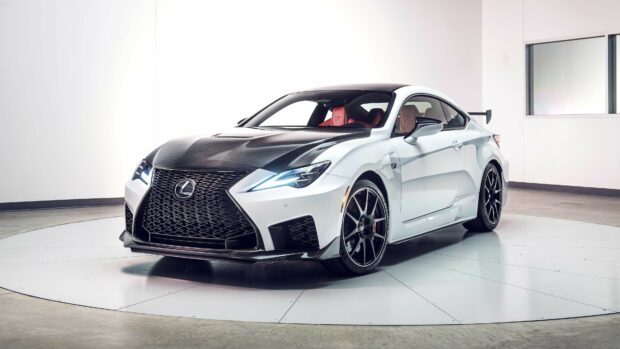 White Lexus sports car with carbon fiber hood and black wheels in a studio setting