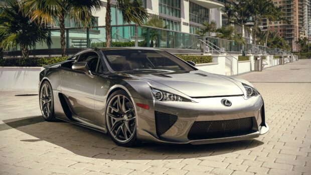 A sleek Lexus sports car parked on a sunny urban street with palm trees in the background
