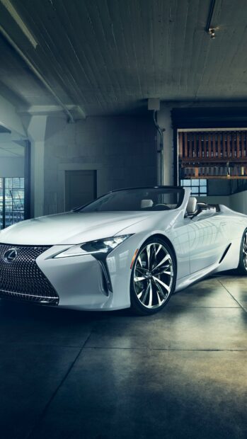 A white Lexus convertible parked inside an industrial garage with polished wheels and sleek design