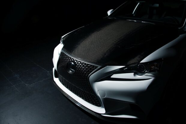 Close up of Lexus carbon fiber hood and front grille in dark setting