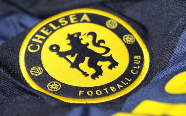 Close up of Chelsea logo embroidered on a black and yellow football club jersey