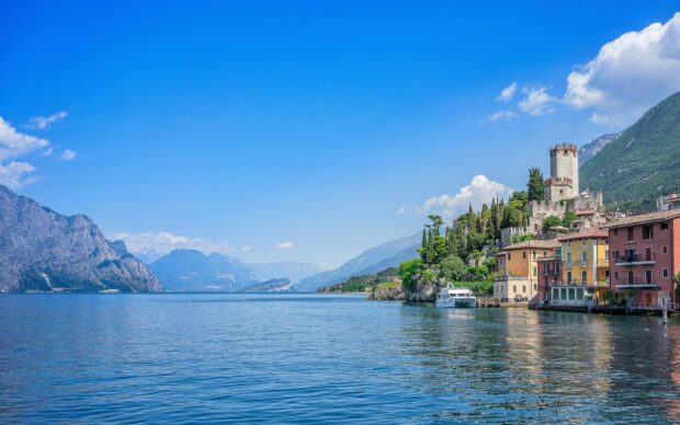 Scenic view of Lombardy coastline with mountains and historic buildings by the lake