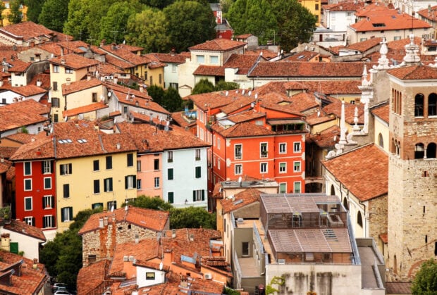 Aerial view of colorful buildings in Lombardy with terracotta roofs and lush green trees