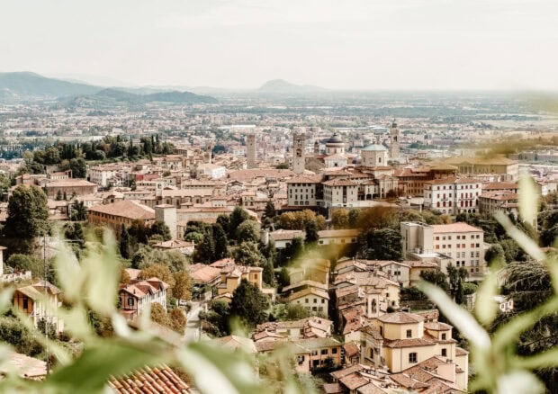A panoramic view of Lombardy cityscape with historic buildings and lush greenery